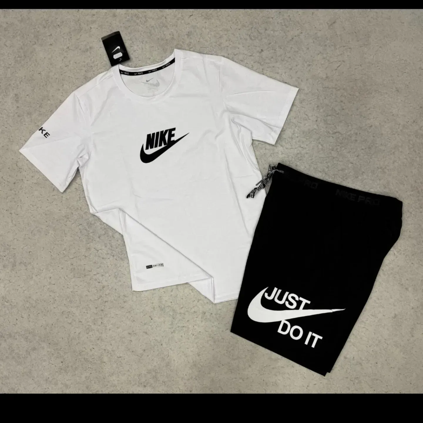 Camiseta Nike blanca con logotipo negro y pantalón corto negro con el logotipo
