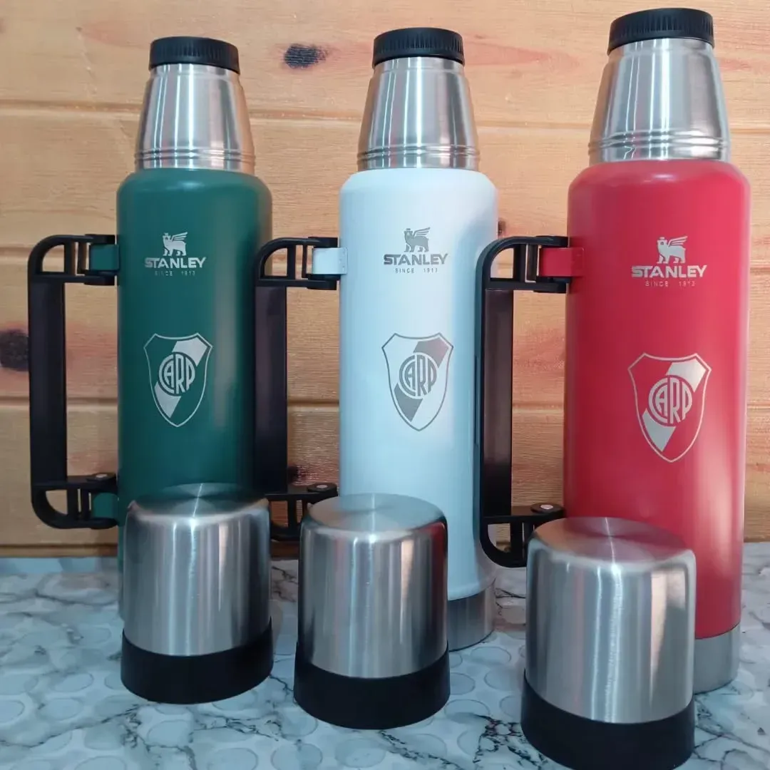 Tres termos Stanley en verde, blanco y rojo con asas, cada uno con el logo de River Plate.