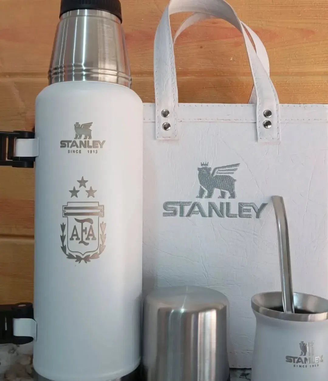 Termos, mate y otros accesorios marca Stanley de color rojo en exhibición.