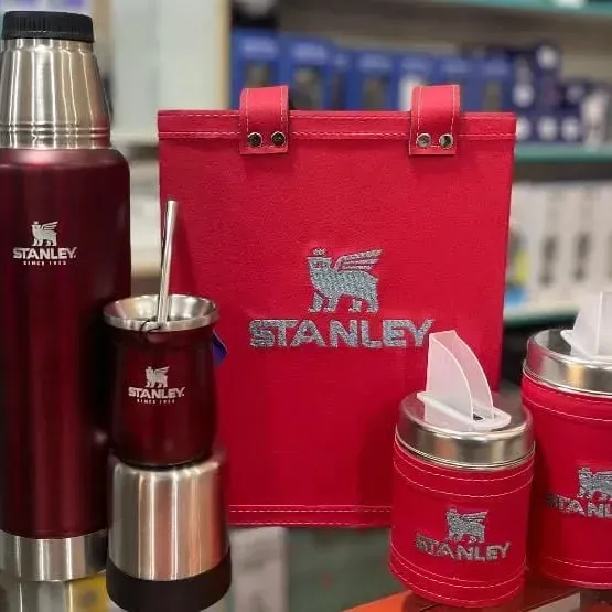 Termos, mate y otros accesorios marca Stanley de color rojo en exhibición.