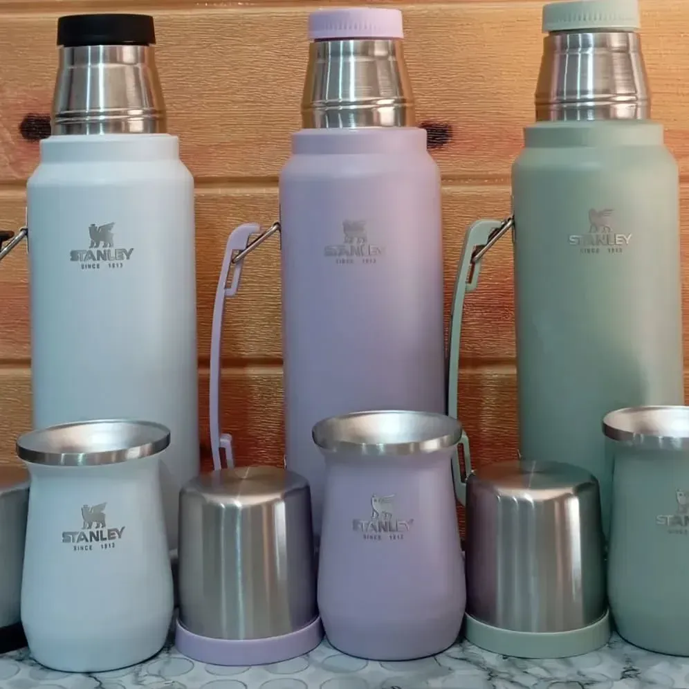 Tres termos Stanley y tres vasos a juego en azul claro, morado y verde.