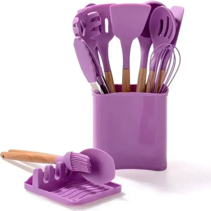 Juego de utensilios de cocina de silicona morada con mangos de madera en un soporte morado, con reposacucharas.
