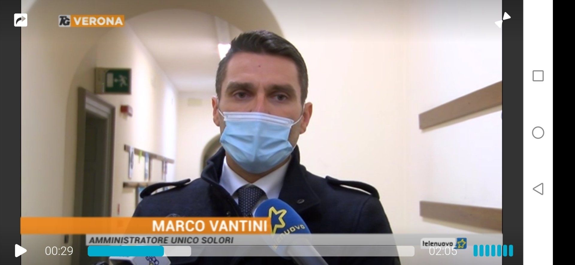 Un uomo in giacca e cravatta indossa una maschera.