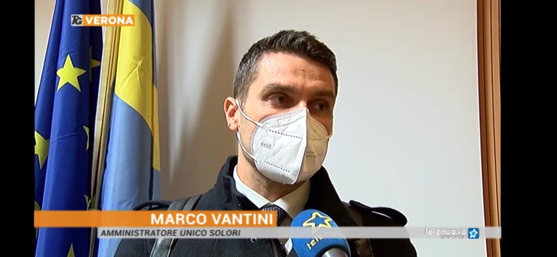 Un uomo che indossa una maschera parla al microfono.