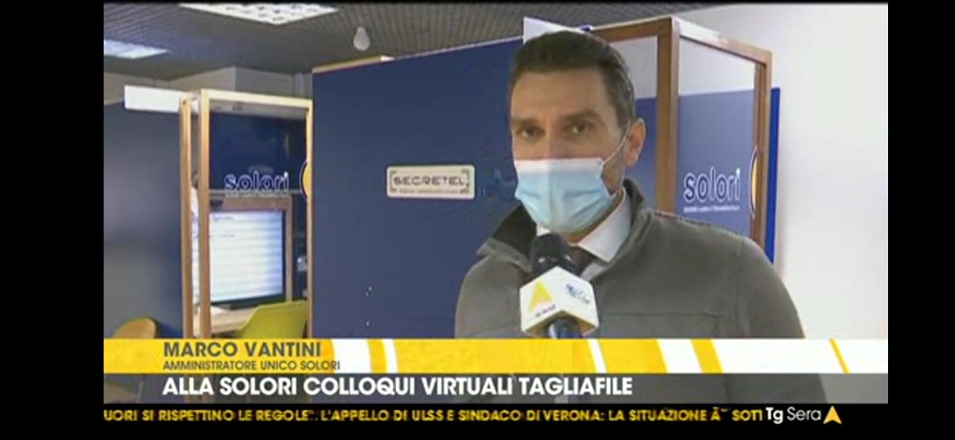 Un uomo che indossa una maschera parla al microfono