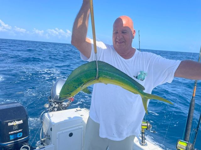 A man on a boat holding a fish in his hand