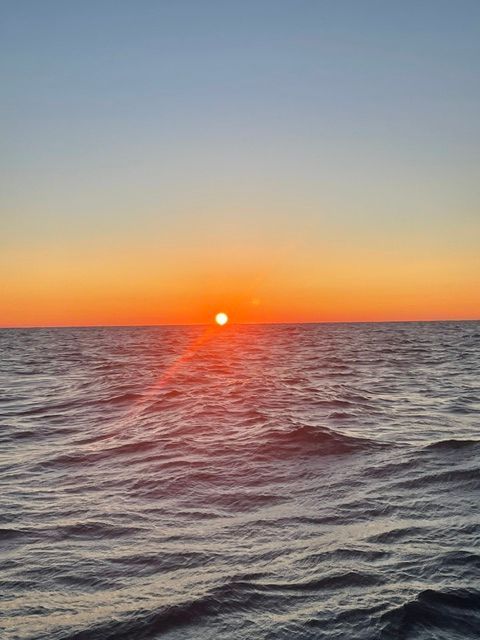 The sun is setting over the ocean.