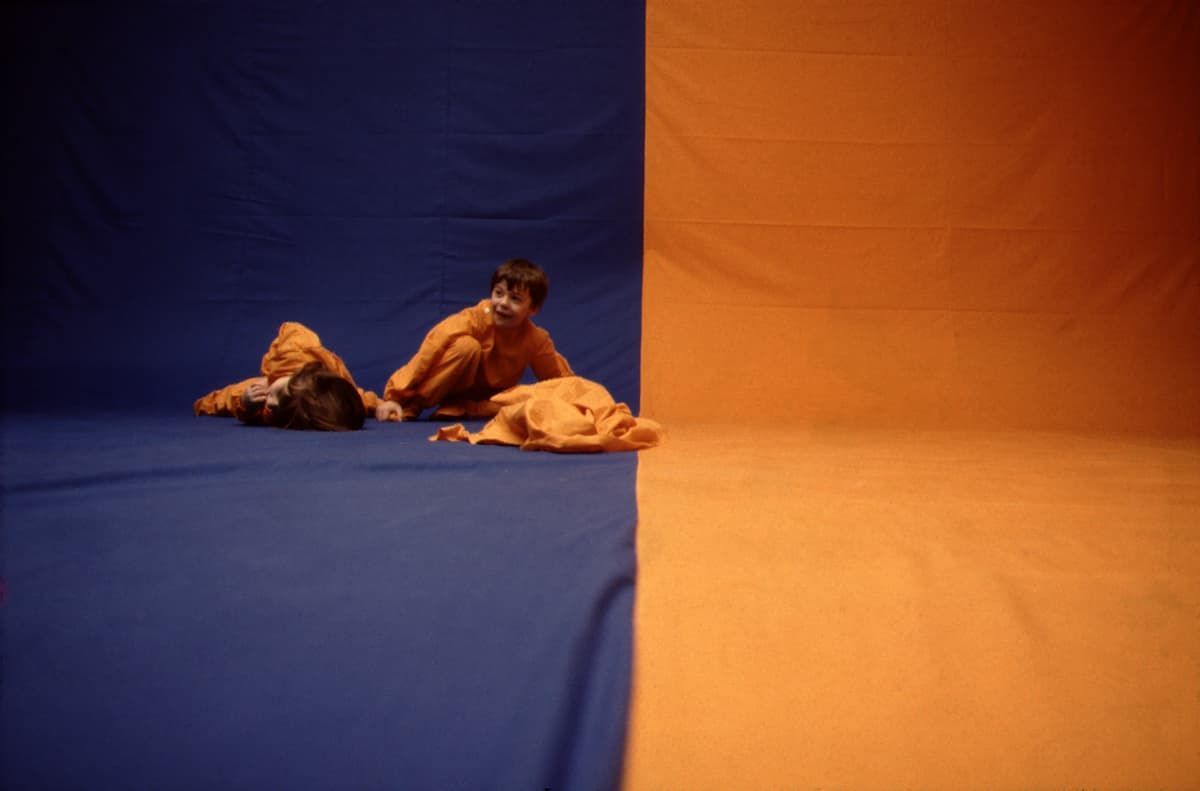 2 bambini stanno giocando su uno sfondo giallo e blu.