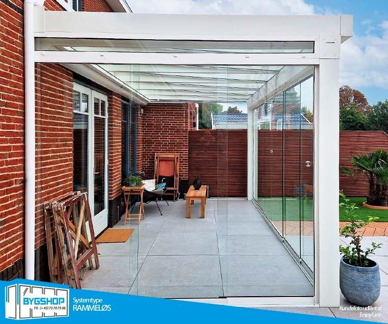 Hvid uisoleret udestue med rammeløse glasskydedøre. Monteret af Enjoyline i Holland.