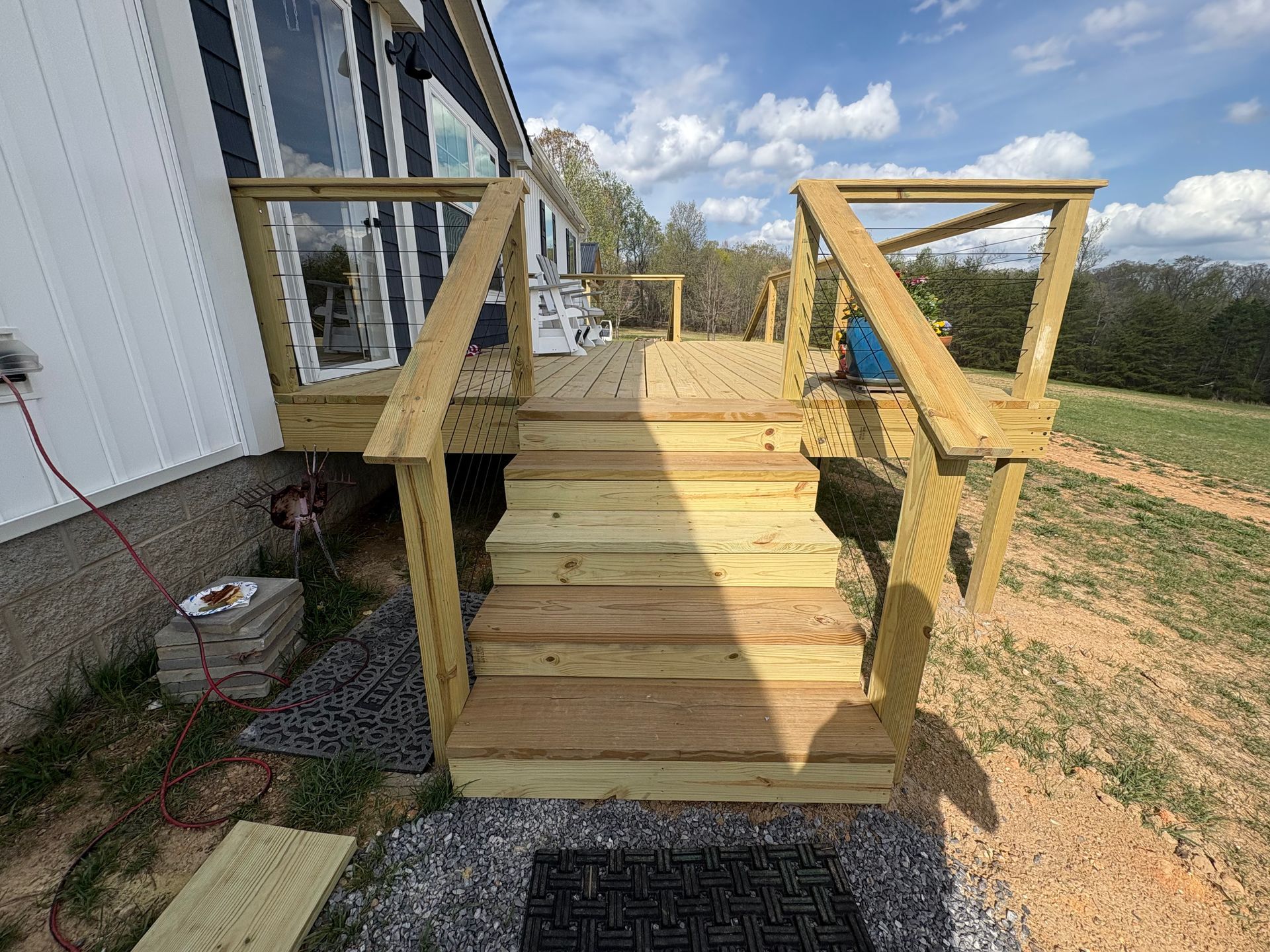 Wooden deck and stairs leading from a house, built on a sloped yard.