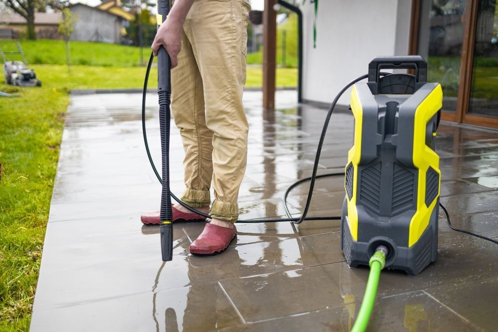 A man is using a high pressure washer.