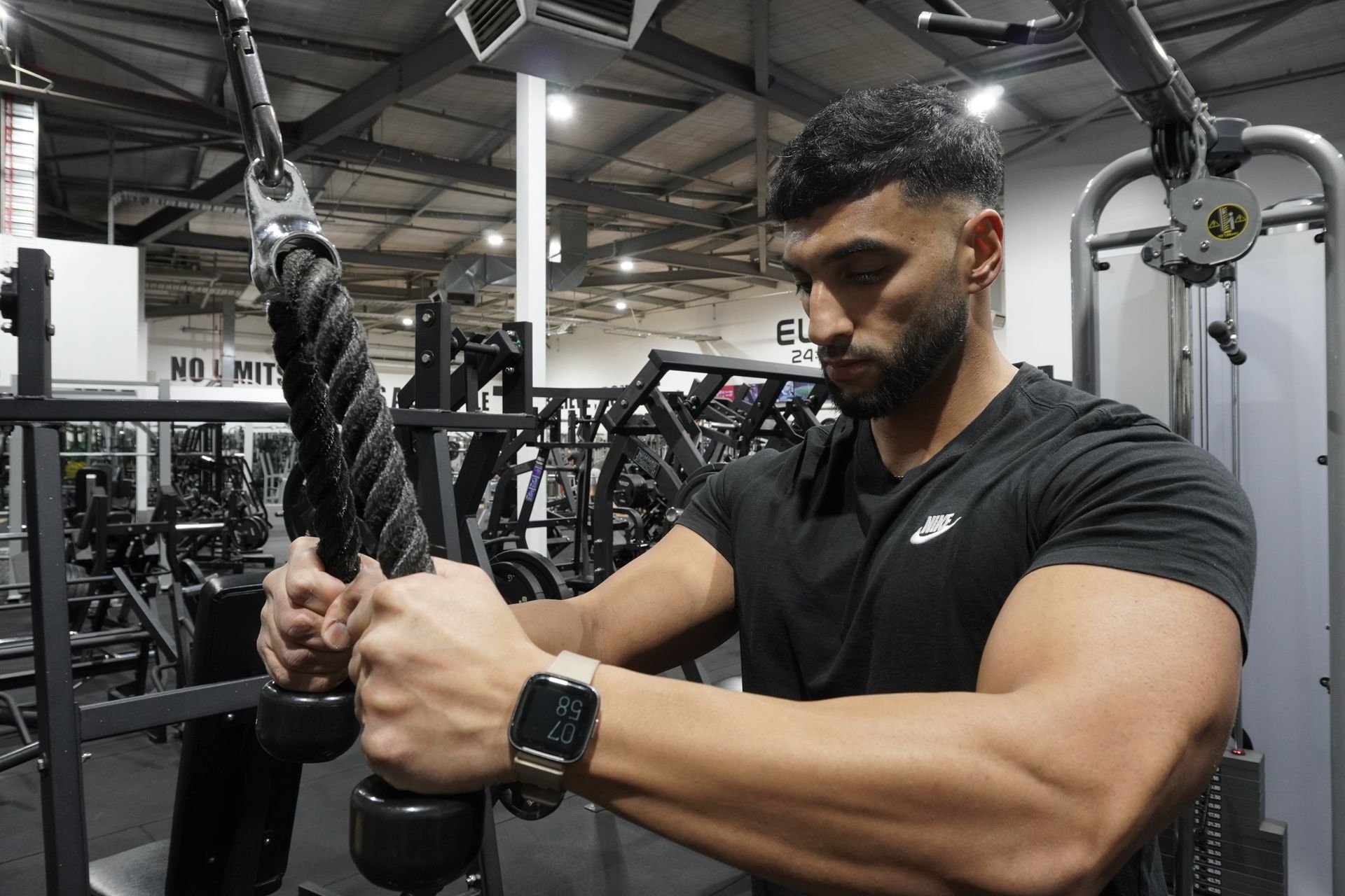 Manni kumar s is holding a rope in a gym.