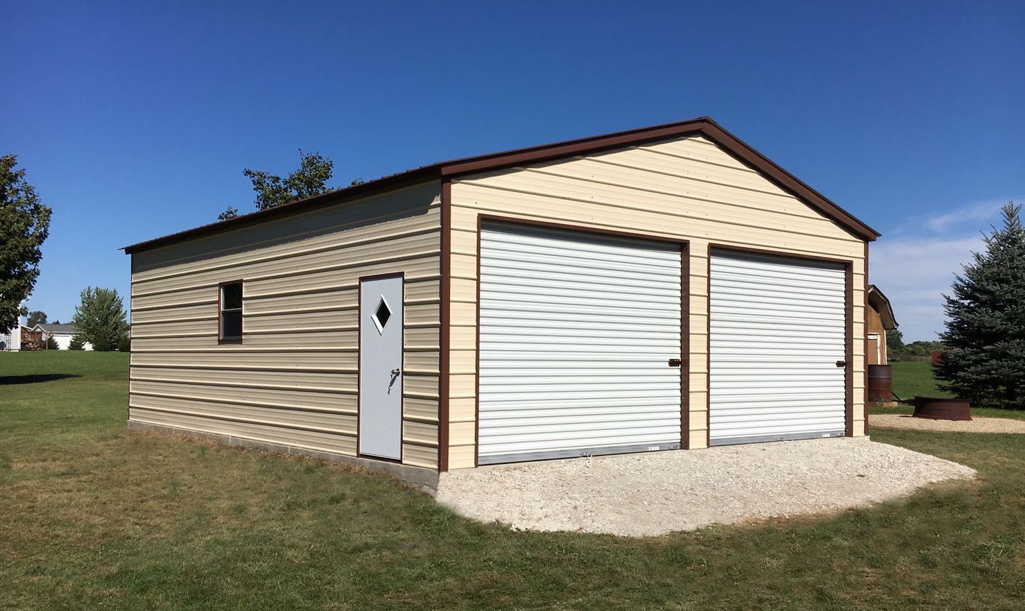 24 foot by 30 foot by 9 foot two car metal garage with an A-frame roof, beige siding and brown trim.