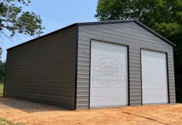 30'x35'x12' Commercial Metal Garage. A frame vertical roof. Silver with black trim and two white 10'x12' roll up doors.