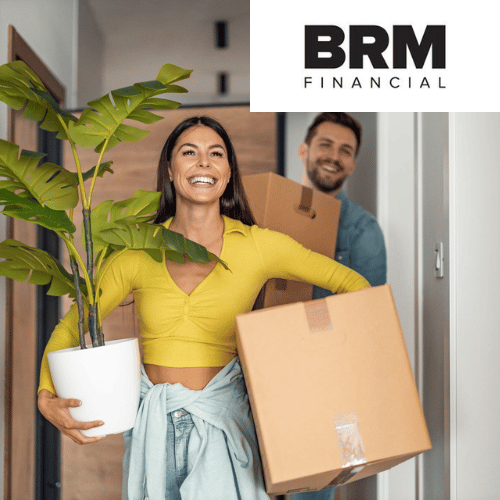 a woman is holding a potted plant and a box while a man is carrying boxes .