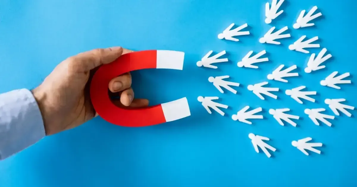 A person is holding a red and white magnet in their hand.