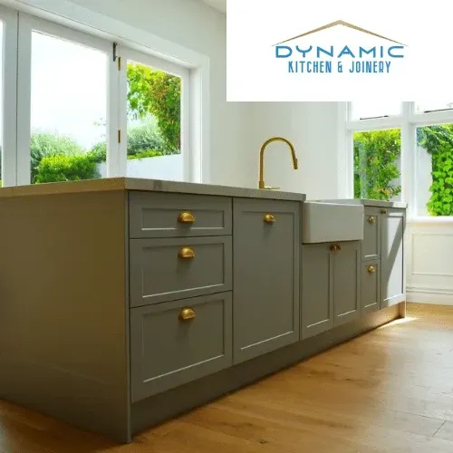 A kitchen with a sink and drawers and a dynamic kitchen and joinery logo