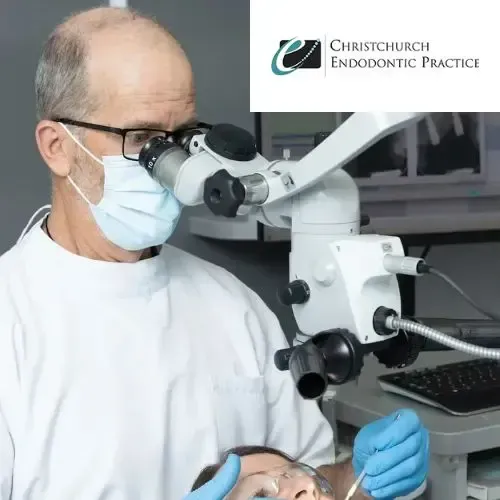 A dentist is using a microscope to look at a patient 's teeth