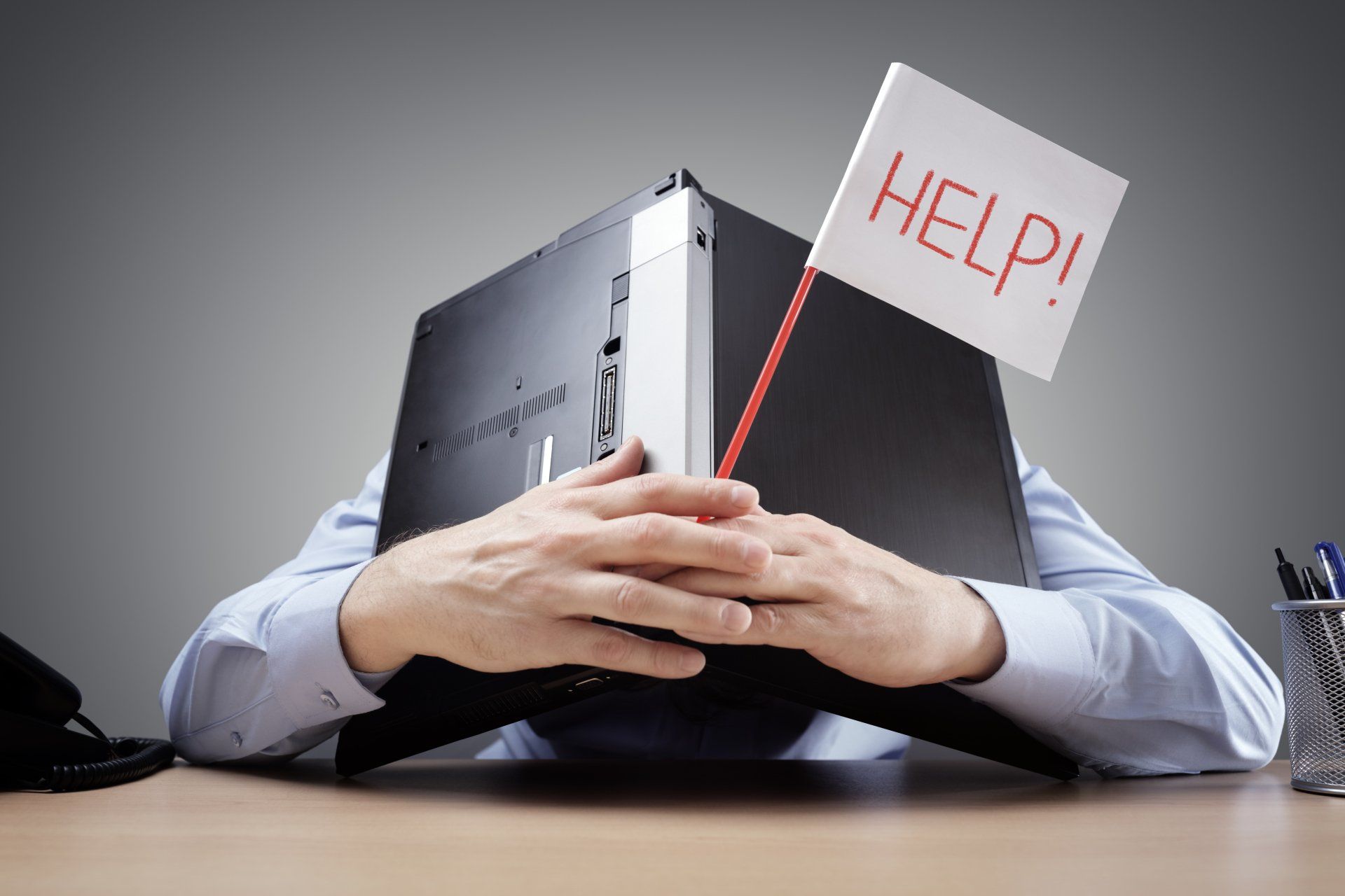 A man is holding a sign that says help in front of his head.