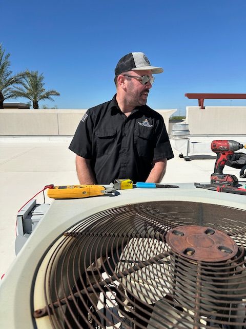HVAC technician on a rooftop. He's looking left, near AC unit and tools on a sunny day.