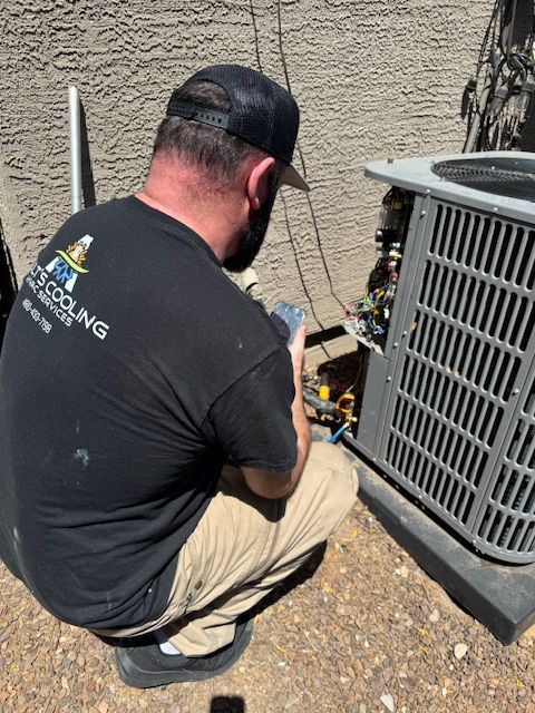 HVAC technician working on an air conditioning unit outside a building.