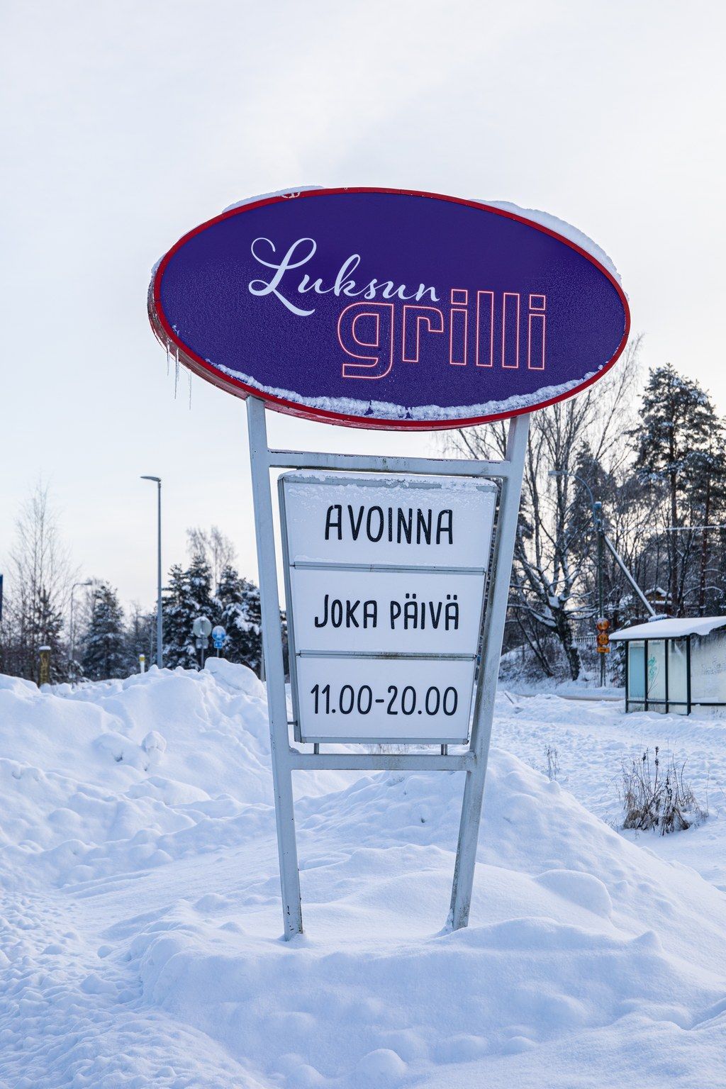 Violetti kyltti lumen peittämän kentän keskellä.