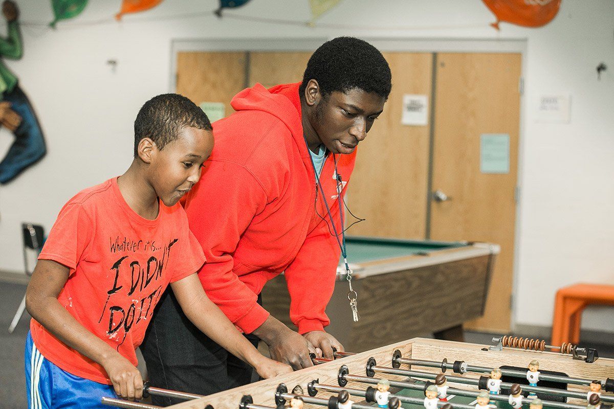 Adult male and boy playing foosball