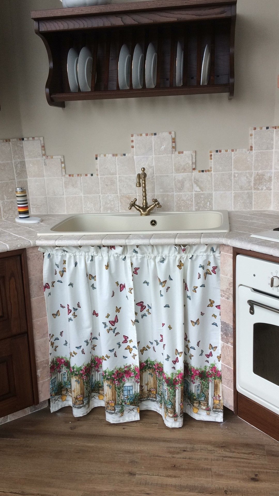 Una cucina con un lavandino e una tenda sotto.