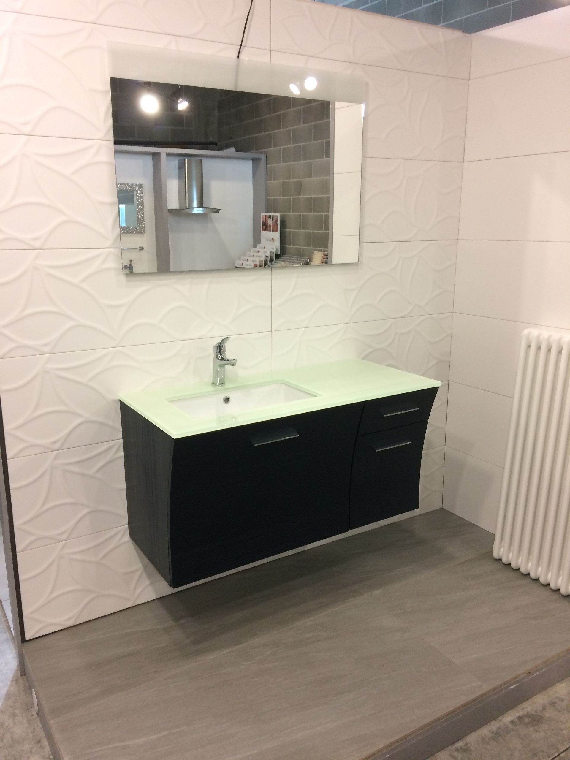 Un bagno con un lavandino e uno specchio sul muro