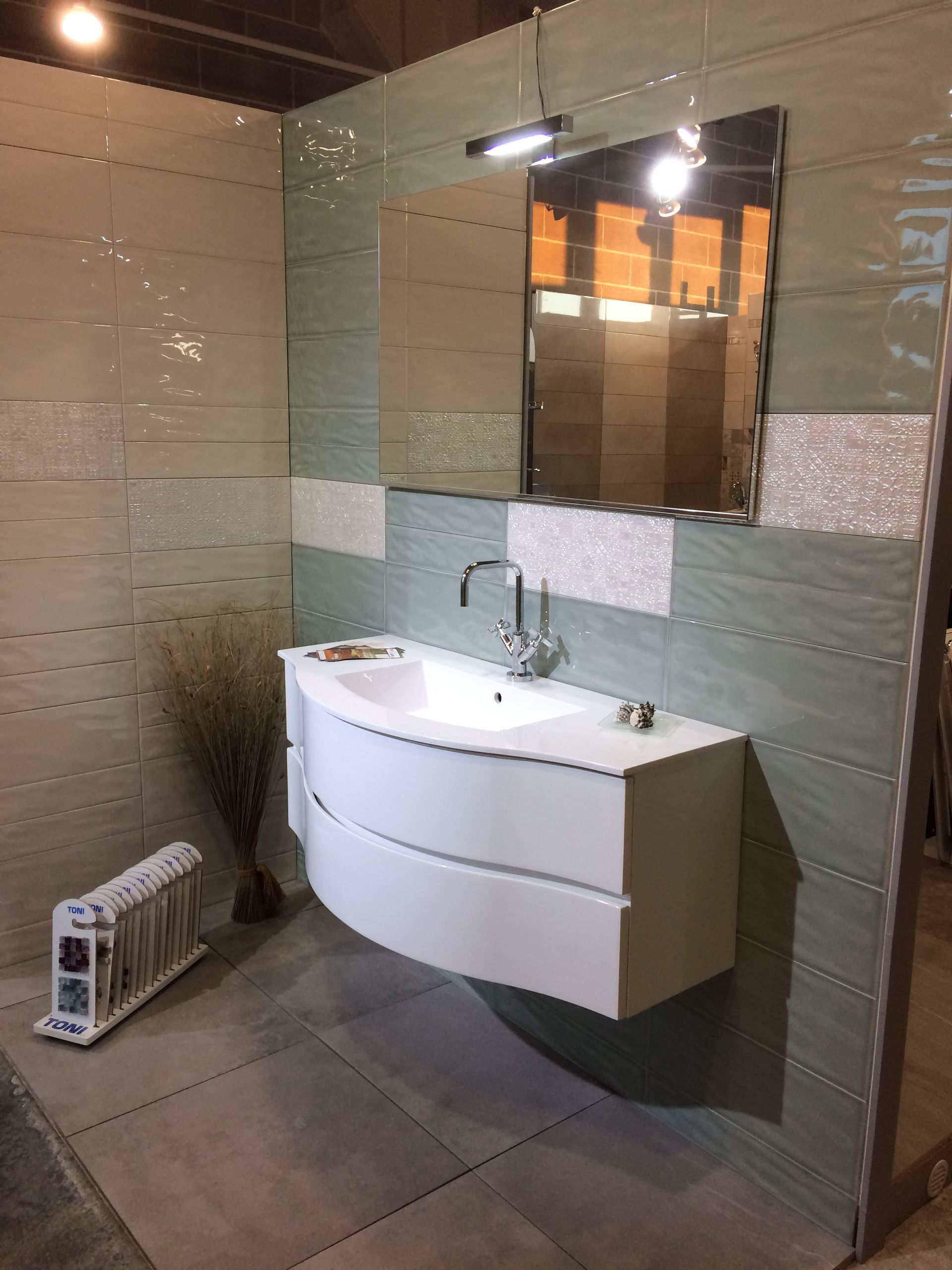 Un bagno con un lavandino e uno specchio sul muro