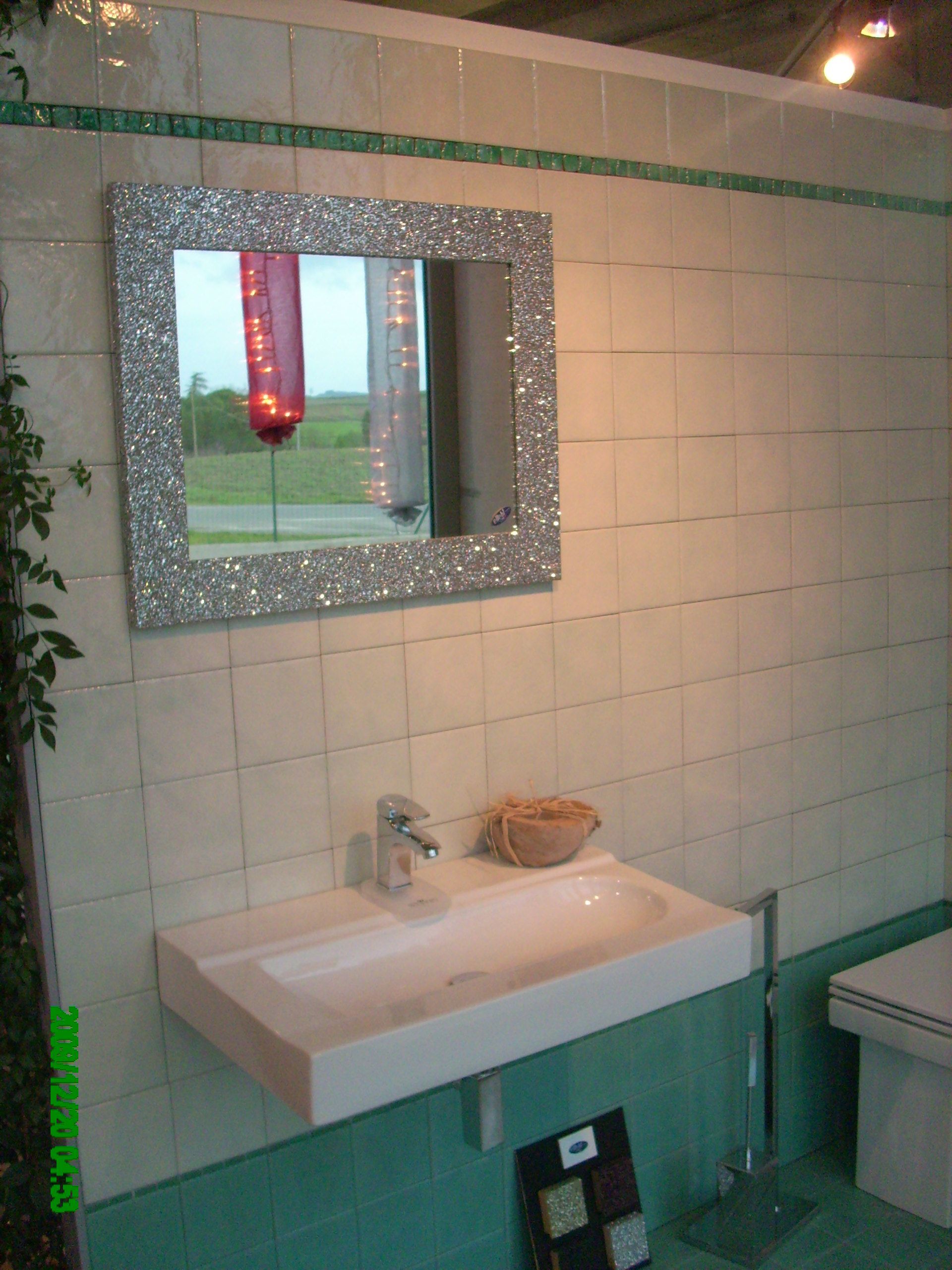 Un bagno con un lavandino e uno specchio sul muro