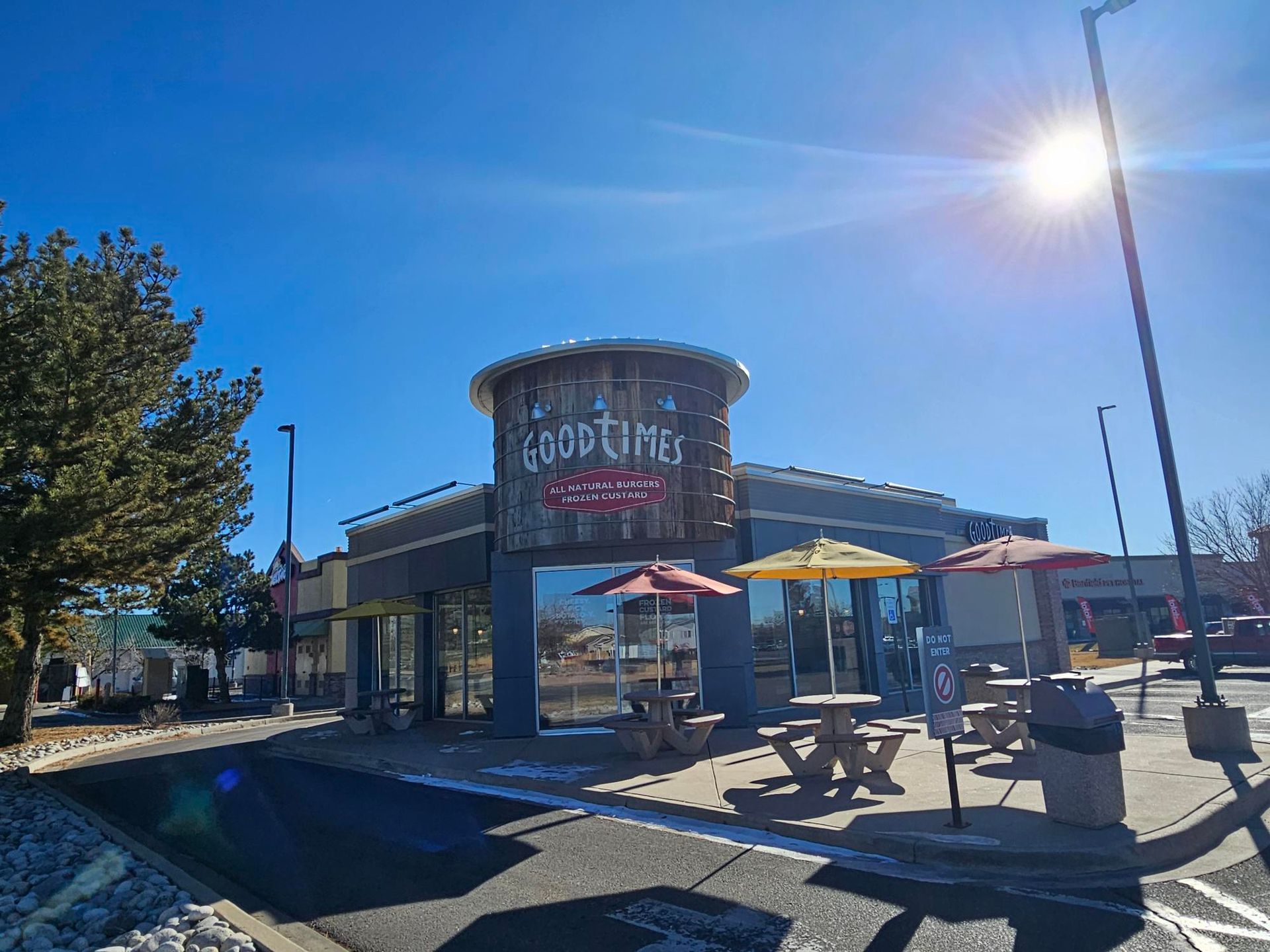 A restaurant with tables and umbrellas outside on a sunny day.