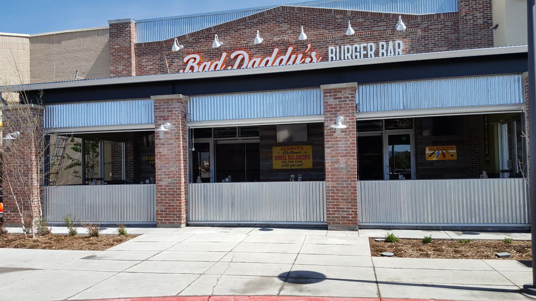 A restaurant called bad daddy 's burger bar is located in a brick building.