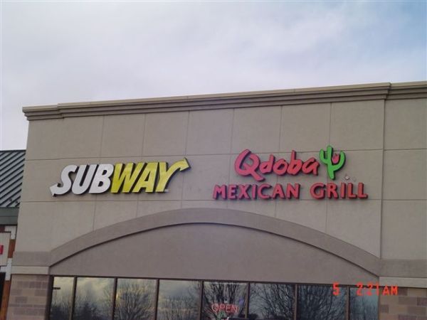 Subway and qdoba mexican grill signs on a building