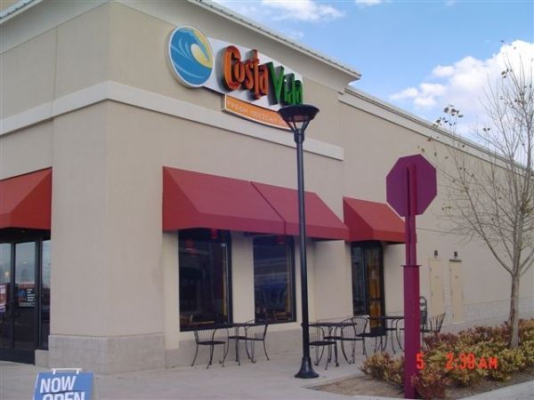The outside of a costa vida restaurant with red awnings