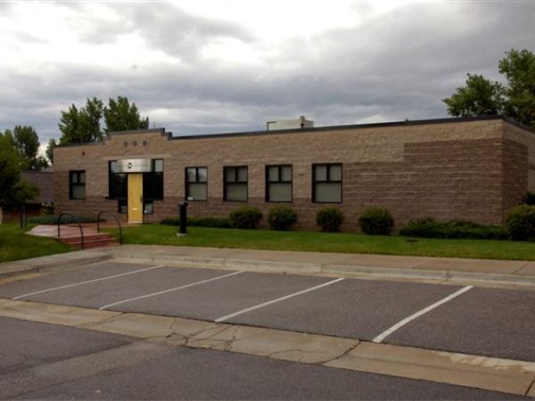A brick building with a yellow pole in front of it