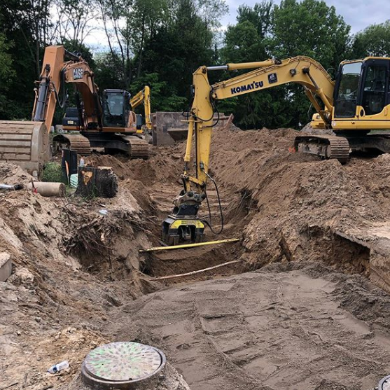 A komatsu excavator is digging a hole in the dirt