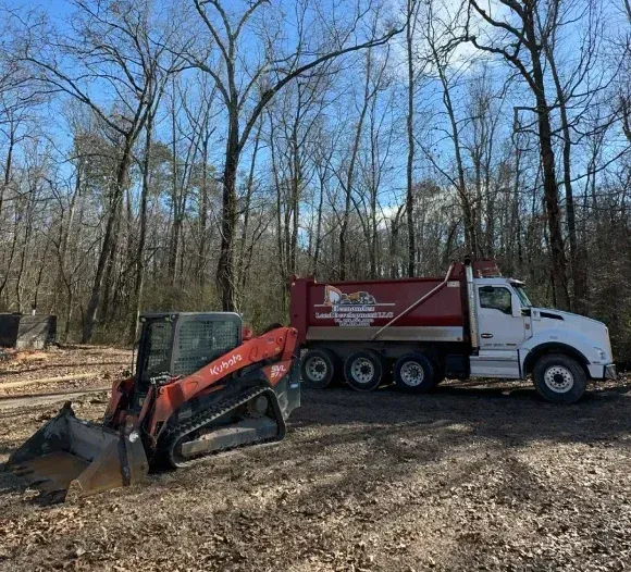 A dump truck with a bulldozer attached to it