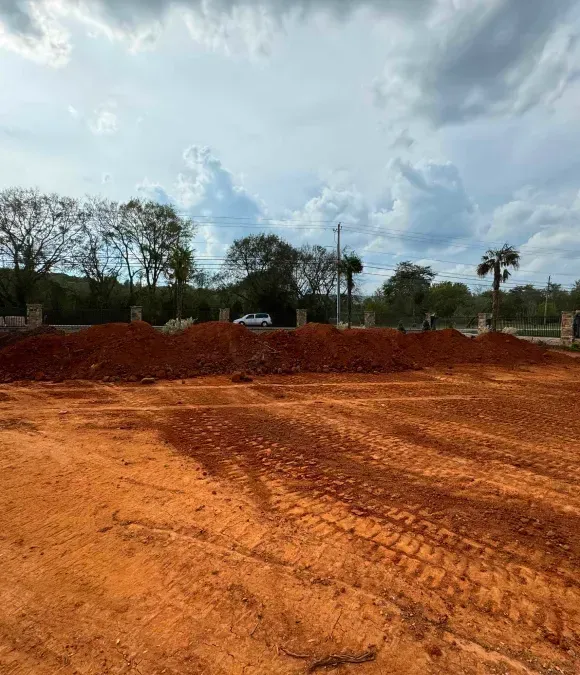 A large pile of dirt is sitting in the middle of a dirt field.