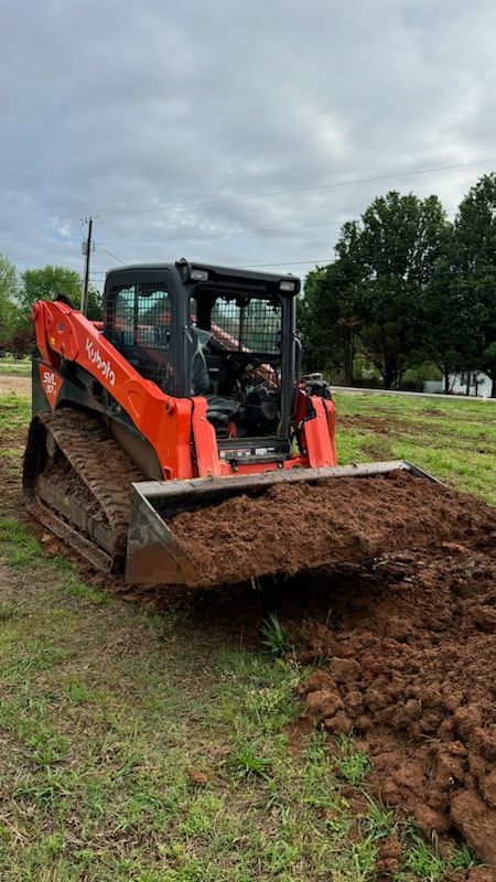 A bulldozer is moving dirt in a field.