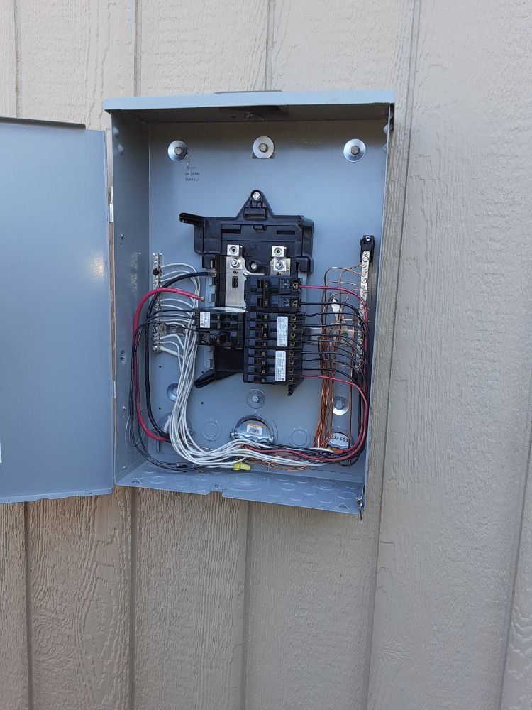 A electrical box is sitting on a wooden wall.