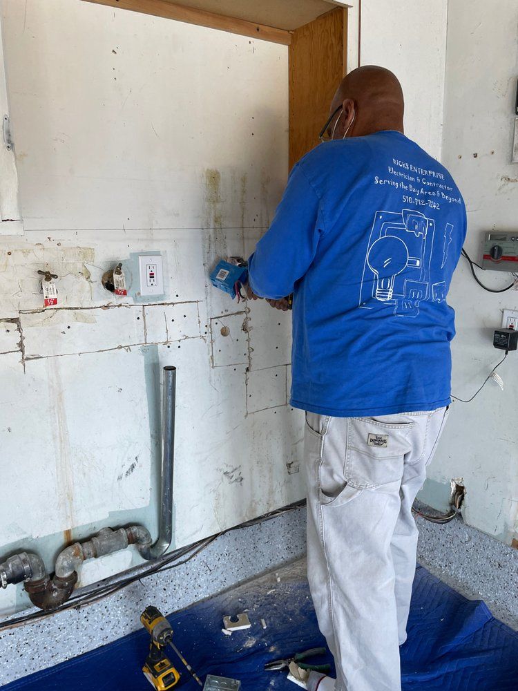 A man in a blue shirt is working on a wall.