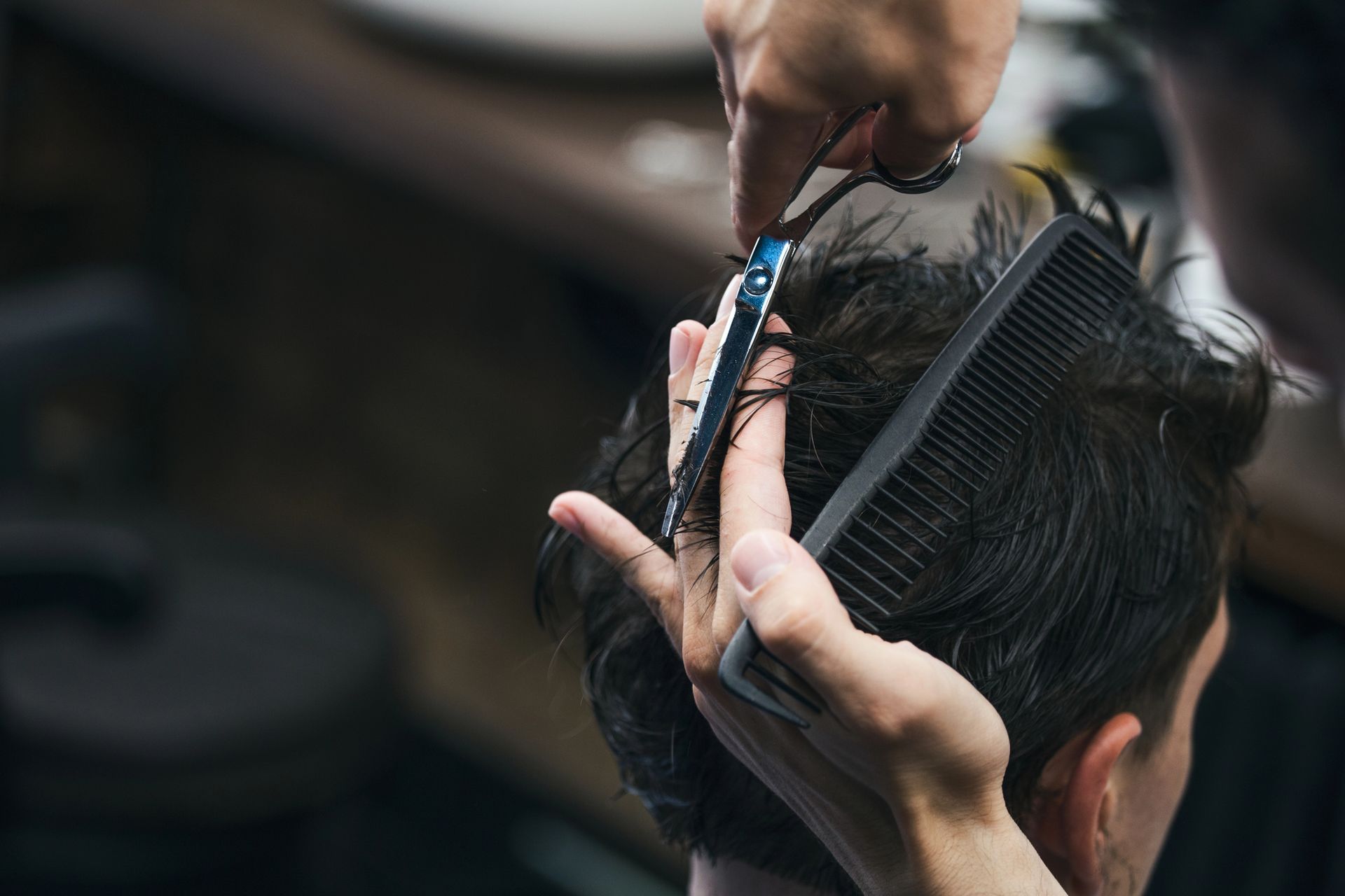 Barbiere che taglia i capelli con forbici e pettine.