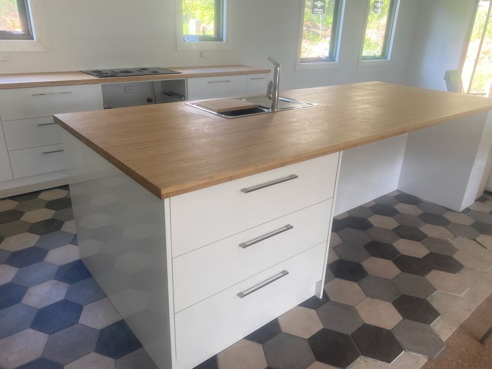 A Kitchen with a Wooden Countertop and White Cabinets — 4Shaw Kitchens in Dubbo, NSW