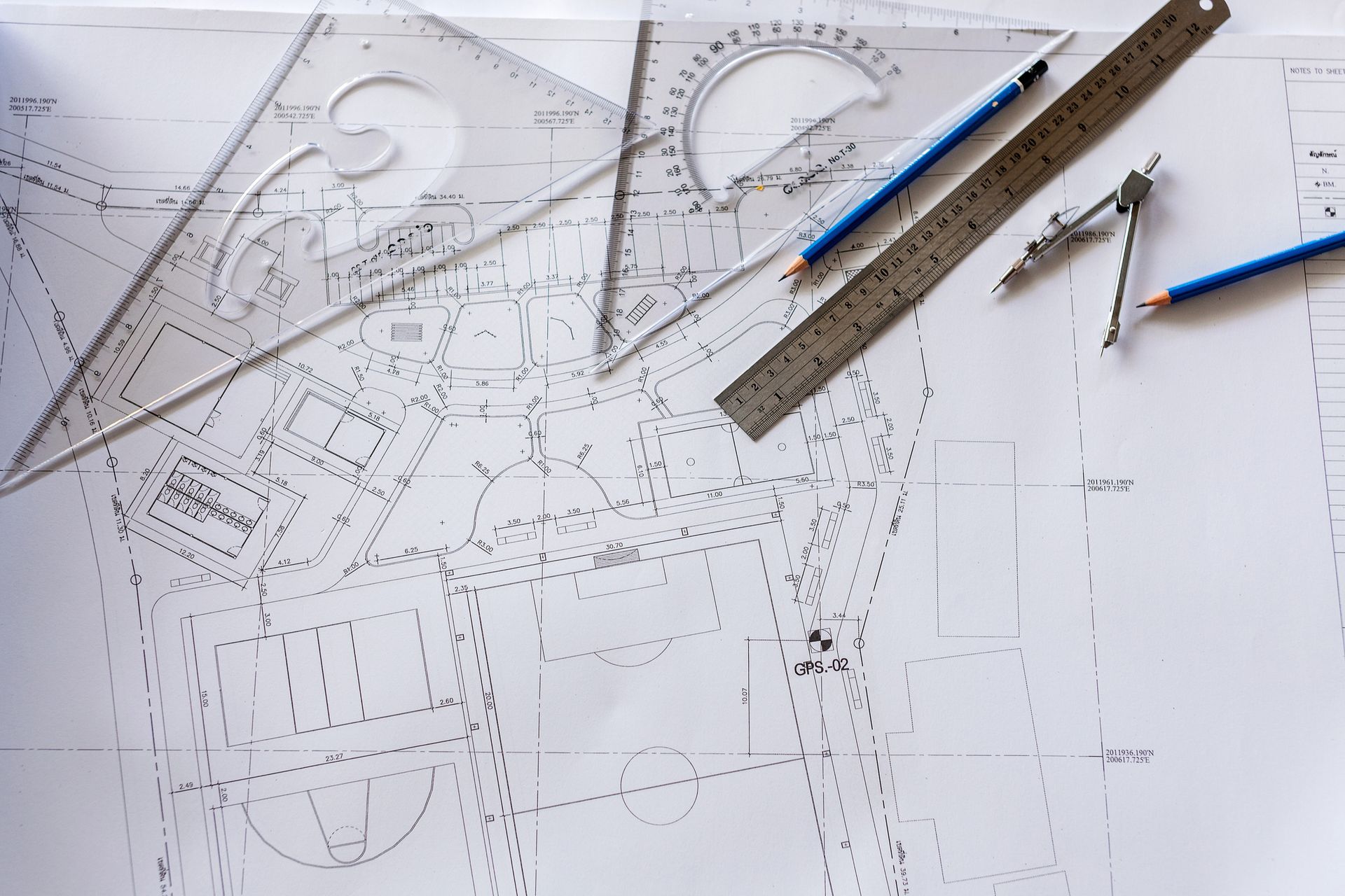 Close-up of architect house designs drawing plan on blueprint with rulers and pencils on top.