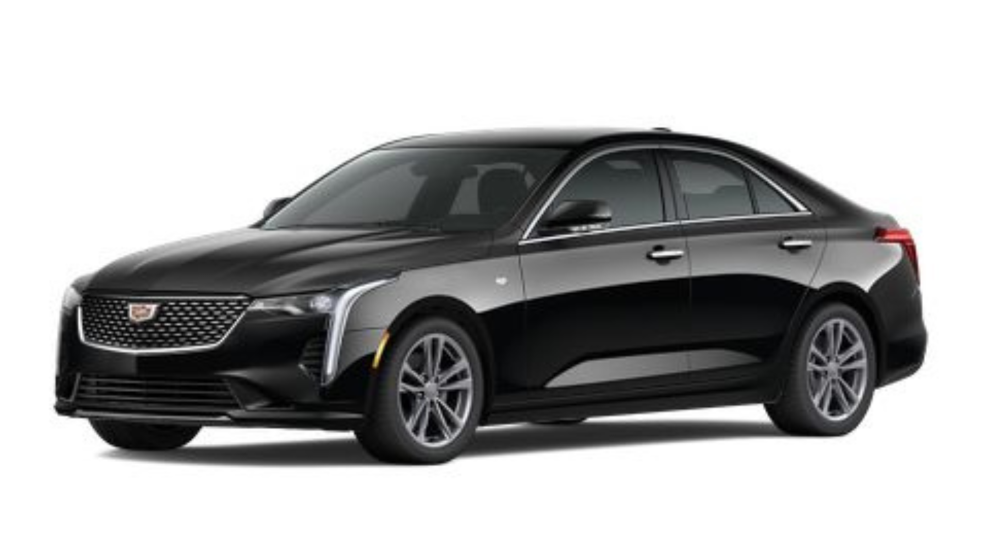 A black car is parked in a dark room