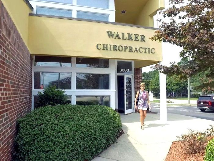 a woman is walking towards walker chiropractic