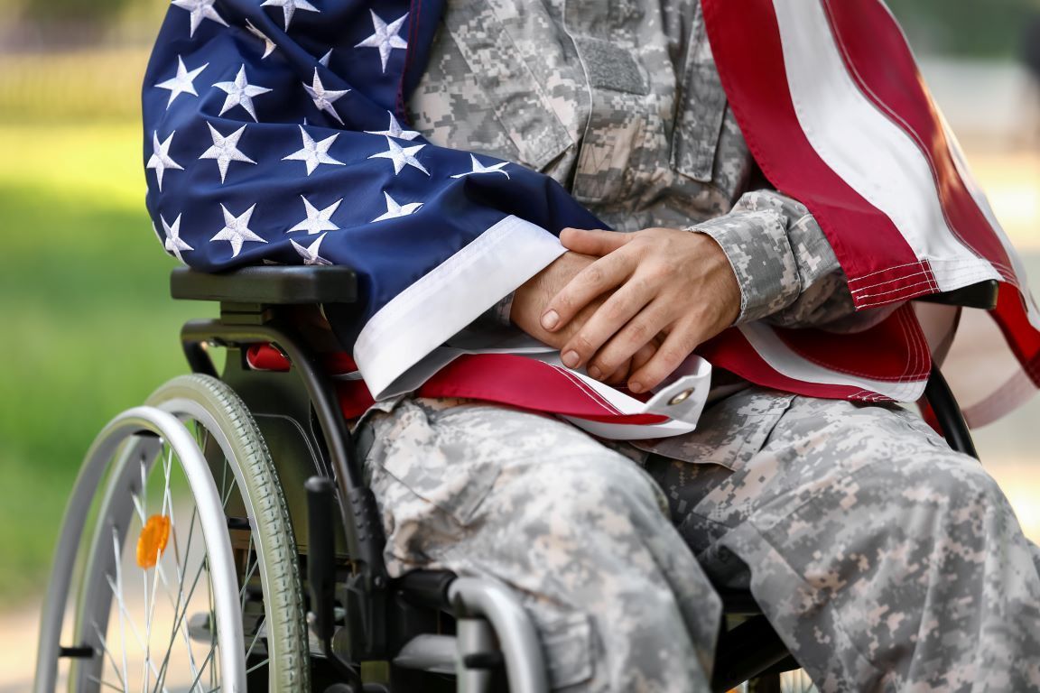 a soldier in a wheelchair is holding an american flag