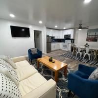 A living room with a couch , chairs , coffee table and television.