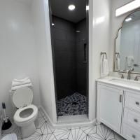 A bathroom with a toilet , sink , mirror and shower.